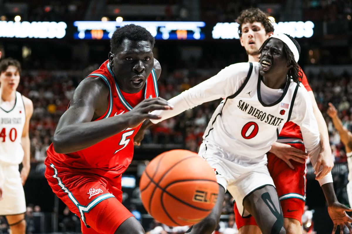 New Mexico Antonio Chol (5) and San Diego State's Magoon Gwath (0) go for the ball while it goes out of bounds during the semifinal of Mountain West Championship tournament game between San Diego State and New Mexico on Friday March 13, 2026 in Las Vegas, Nev.