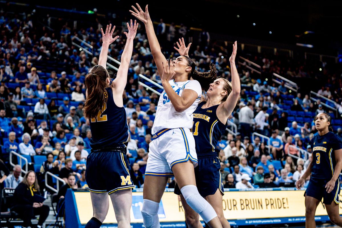 UCLA C Lauren Betts (51) scores over two defenders during an NCAA basketball game against the Michigan Wolverans, Wednesday January 1st, 2025 in Los Angeles, California. 