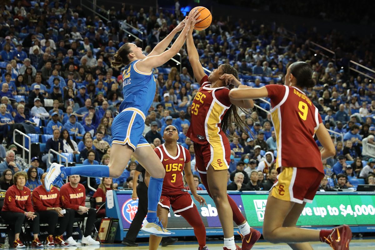 UCLA forward Angela Dugalic (32) and USC guard Kara Dunn (25) battle for possession of the basketball during an NCAA basketball on January 3, 2026 in Los Angeles, CA.