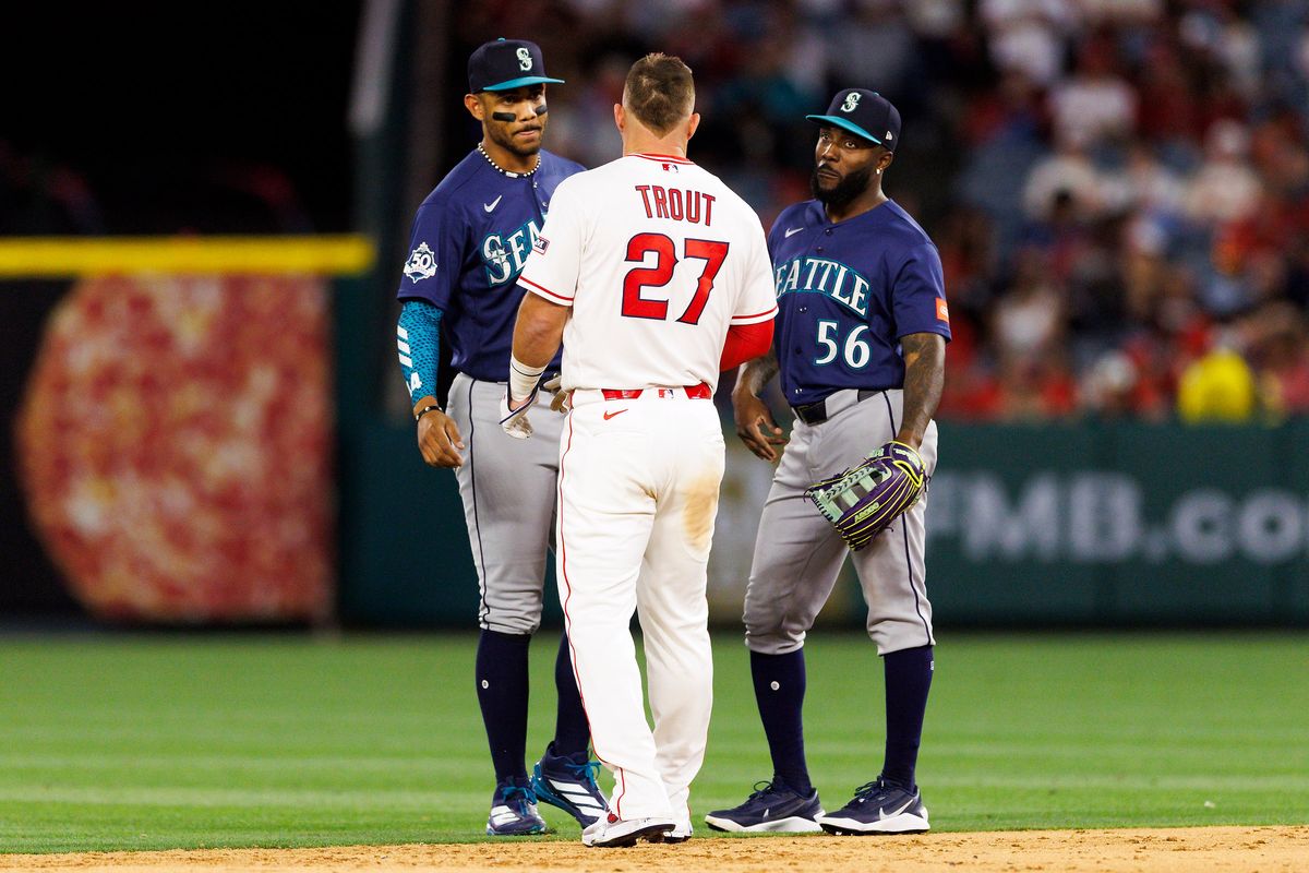 Mike Trout #27 of the Los Angeles Angels talks to Julio Rodriguez #44 of the Seattle Mariners and Randy Arozarena #56 of the Seattle Mariners during the game at Angel Stadium of Anaheim on April 3, 2026 in Anaheim, California.