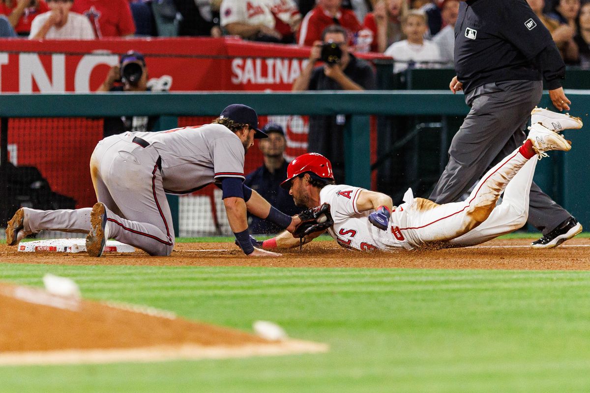 Austin Riley #27 of the Atlanta Braves tags Josh Lowe #3 of the Los Angeles Angels for an out during an MLB game against the Los Angeles Angels at Angel Stadium on April 7, 2026 in Anaheim, California.