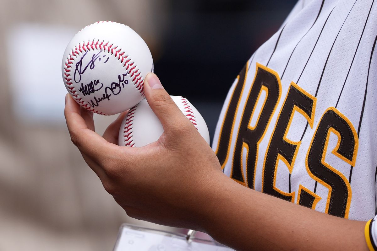 Padres fan holds a signed baseball before an MLB baseball game against the Athletics, Sunday May 24, 2026 in San Diego, California.