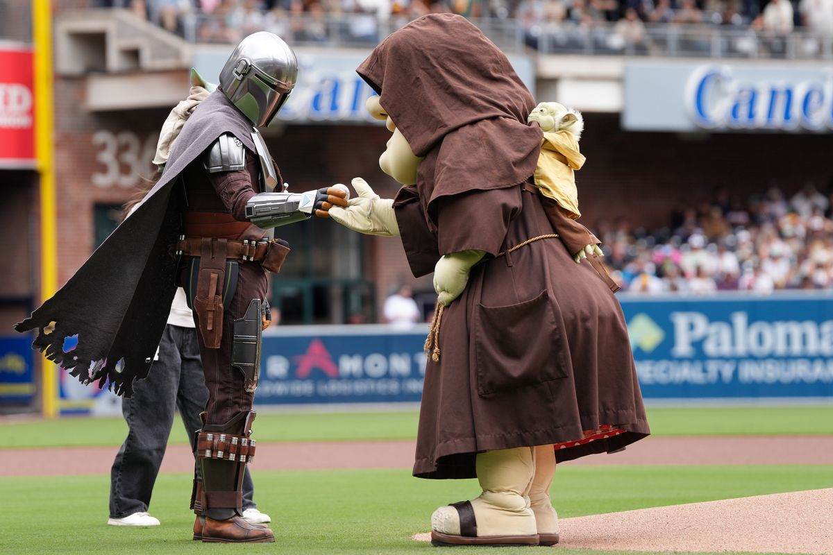 Mandalorian hands off baseball to Padres mascot before an MLB baseball game against the Athletics, Sunday May 24, 2026 in San Diego, California.