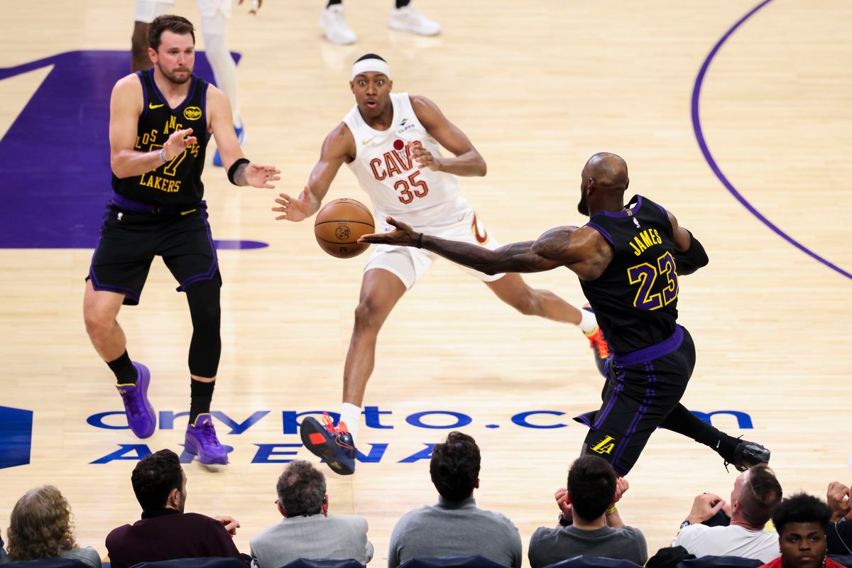 LeBron James #23 of the Los Angeles Lakers saves the ball from going out of bounds as Luka Doncic #77 of the Los Angeles Lakers and Nae’Qwan Tomlin #35 of the Cleveland Cavaliers look on during an NBA basketball game, Tuesday March 31, 2026 in Los Angeles, Calif.