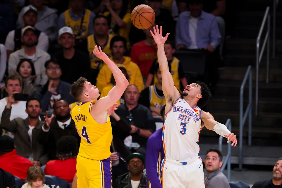Dalton Knecht #4 of the Los Angeles Lakers and Jared McCain #3 of the Oklahoma City Thunder reach for a loose ball during an NBA basketball game, Tuesday April 7, 2026 in Los Angeles, Calif.